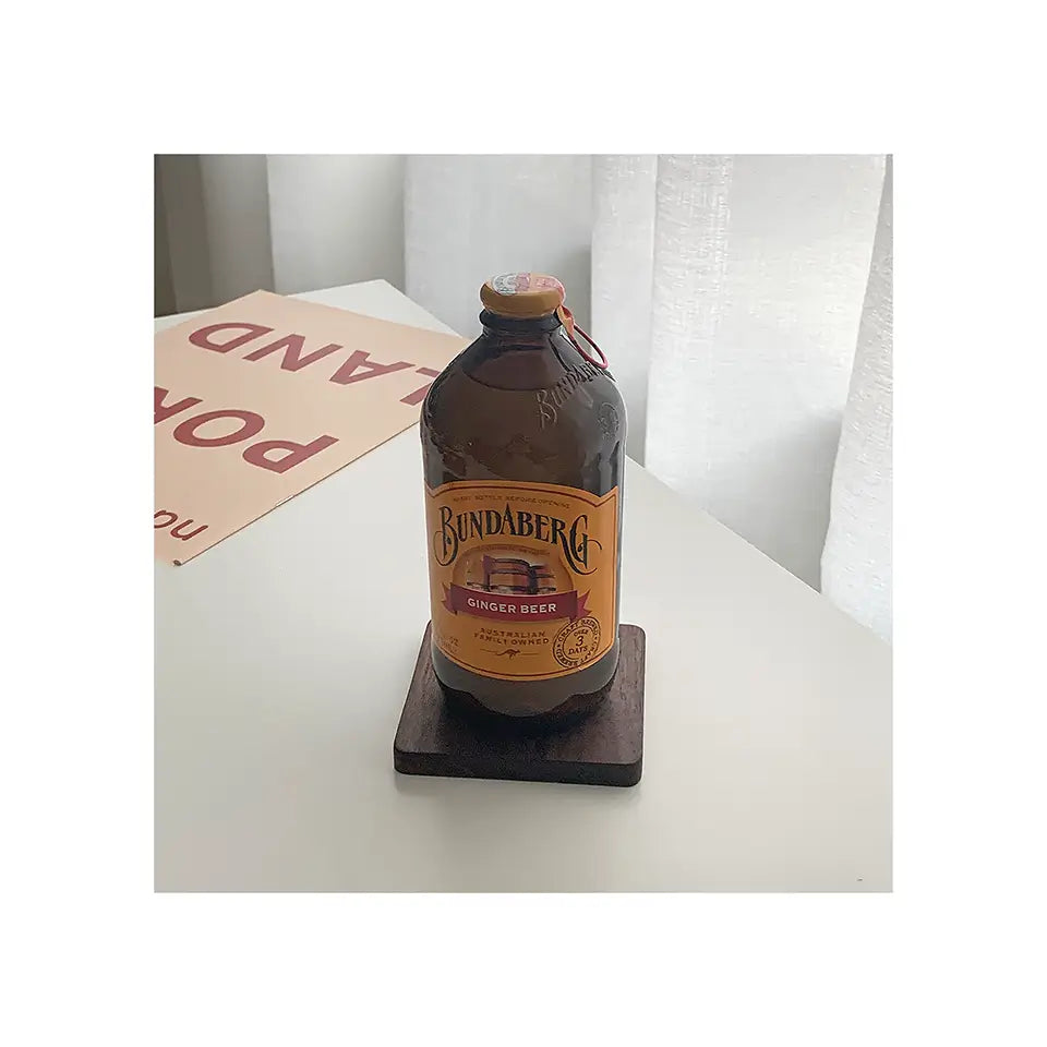 ForestCraft Square Japanese Walnut Coaster used to hold a ginger beer